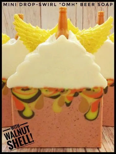 Mini drop-swirl beer soap with creamy foam, colorful swirls, and golden wings on top, showcasing artistic soap design.