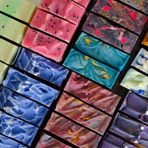 Colorful handmade soap bars in various swirls and patterns, showcasing beauty and creativity in soap making.