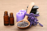 Lavender essential oils, candles, and dried flowers for fragrance blending on a natural background.