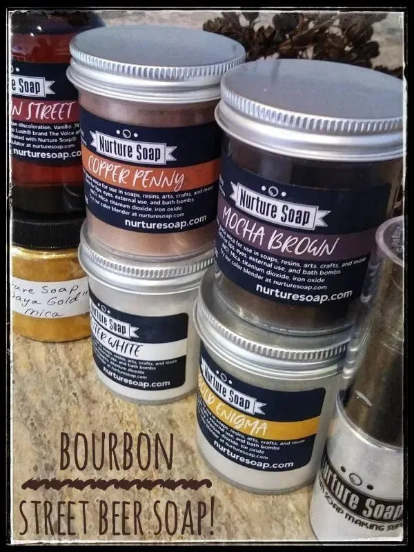 Colorful jars of Bourbon Street Beer Soap and other natural soap varieties on a rustic surface.