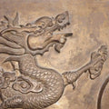 Intricate carving of a dragon surrounded by swirling clouds, showcasing ancient artistry and mystical themes.