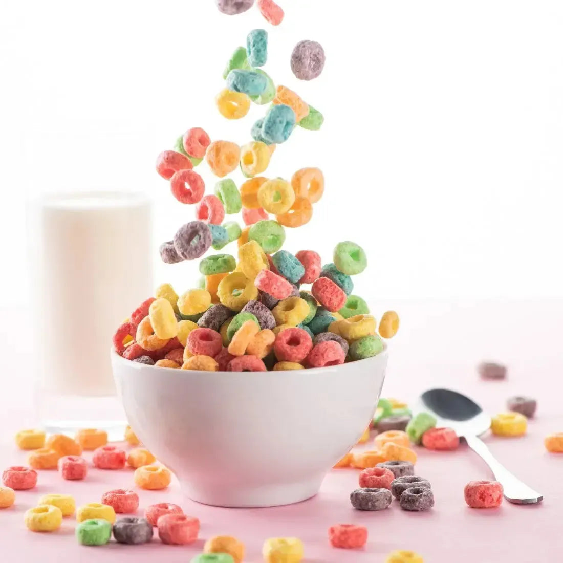 Colorful Fruity O's cereal exploding into a bowl, surrounded by milk and vibrant pieces, evoking joyful breakfast vibes.