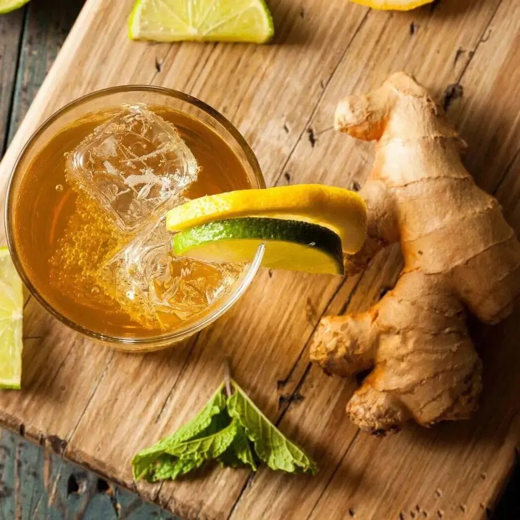 Refreshing drink with ginger, lime, and mint on a wooden surface, evoking a zesty and invigorating vibe.