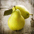 Two ripe green pears with leaves on a rustic wooden background, showcasing nature's juicy sweetness.