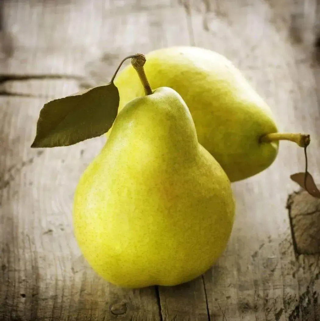 Two ripe green pears with leaves on a rustic wooden background, showcasing nature's juicy sweetness.
