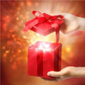 Hand opening a red gift box with glowing lights, perfect for a Nurture Handmade gift card.
