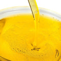 Pouring a rich golden oil blend for soap making, showcasing its smooth texture and quality.