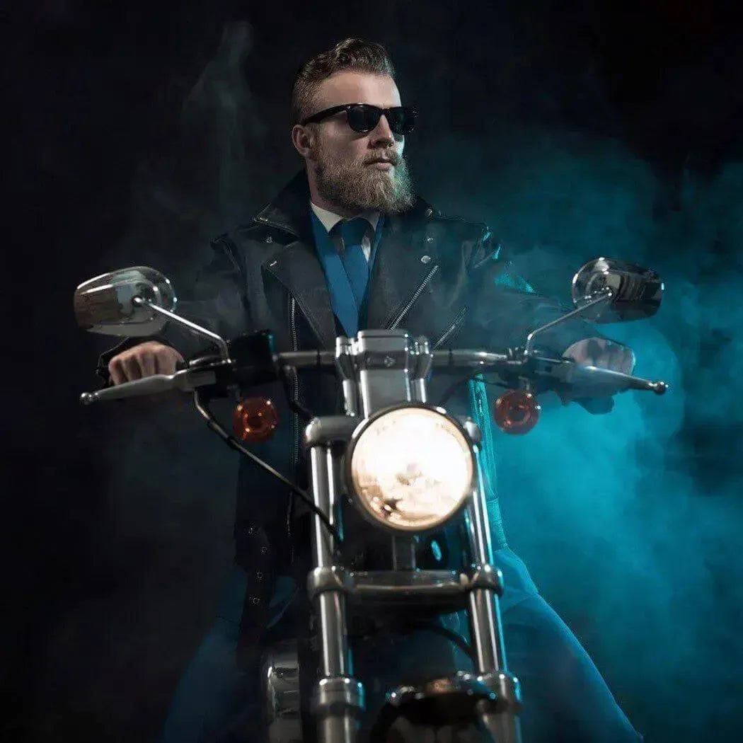 Man in sunglasses riding a motorcycle, exuding confidence with a stylish leather jacket and cool vibe.