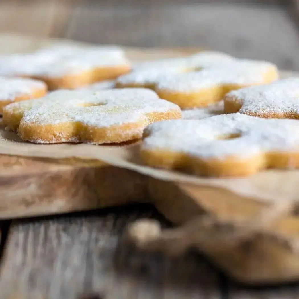 Golden sugar cookies with powdered sugar dusting, reminiscent of homemade treats fresh from Grandma's kitchen.